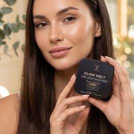 Woman with glowing skin holding a GLOW MELT tin
