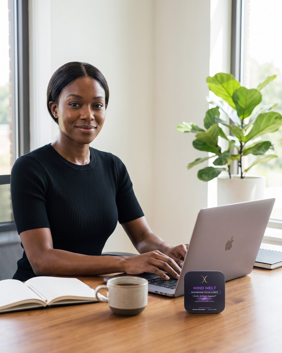 Woman working at a laptop in a bright home office with a MIND MELT tin on the desk